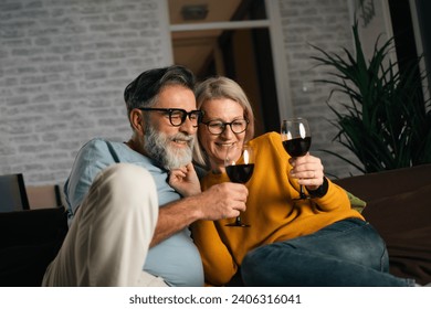 mature couple enjoying wine in the evening at home with TV - Powered by Shutterstock