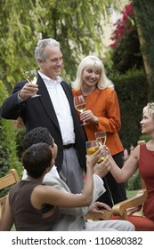 Mature Couple With Friends Toasting Wine Together