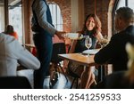 Mature couple getting served white wine by a sommelier at a French bistro restaurant. Happy mature couple having wine on date night. Sommelier serving wine at French bistro restaurant.