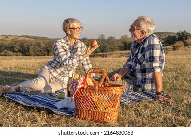 Mature couple have picnic at the middle of the field in nature - Powered by Shutterstock