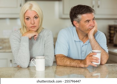 Mature Couple Having Coffee Together Not Talking At Home In The Kitchen