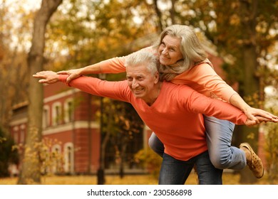 Mature Couple Having Fun In The Autumn Park