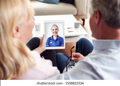 Mature Couple Having Online Consultation With Female Nurse At Home On Digital Tablet