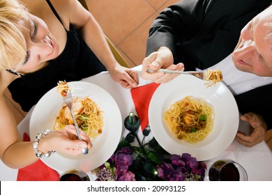 Mature couple having a romantic dinner looking at each other while eating