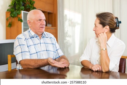 Mature Couple Having Serious Talking At Home Interior. Focus On Man