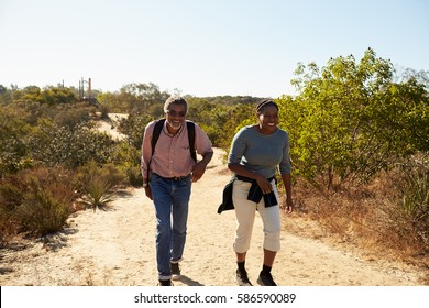 Mature Couple Hiking Outdoors In Countryside Together
