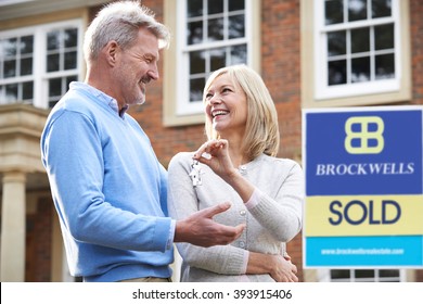 Mature Couple Holding Keys To New Home