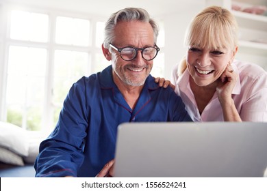 Mature Couple At Home Looking Up Information About Medication Online Using Laptop