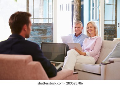 Mature Couple At Home Meeting With Financial Advisor