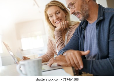Mature couple at home working on laptop computer
