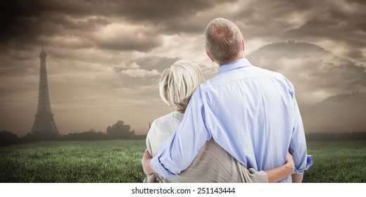 Mature Couple Hugging And Looking Against Paris Under Cloudy Sky