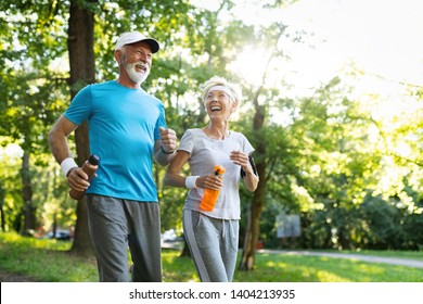 Mature couple jogging and running outdoors in nature