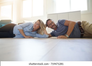 Mature Couple Laying On Floor Of New Home