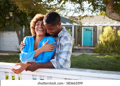 Mature Couple Leaning On Back Yard Fence