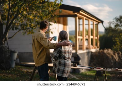 Mature couple looking at their new house under construction, planning future and dreaming.