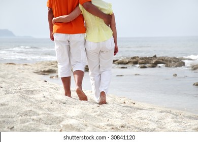 Mature Couple  In Love Walking Along The Beach