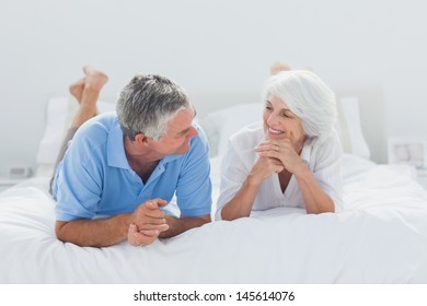 Mature Couple Lying And Talking Together In Bed