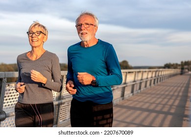 Mature Couple Man And Woman Jogging Outside And Smile