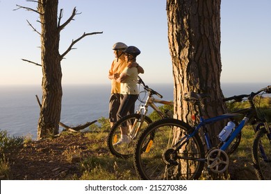 Mature Couple Mountain Biking On Clifftop Trail, Looking At Atlantic Ocean Horizon, Side View