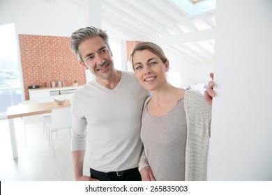 Mature couple opening door of their home