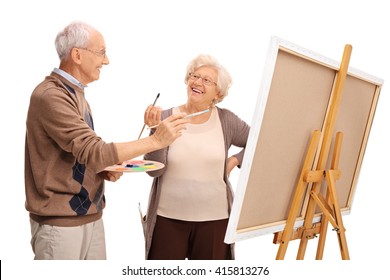 Mature Couple Painting On A Canvas And Having Fun Isolated On White Background