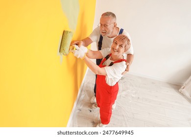 Mature couple painting wall during repair in room - Powered by Shutterstock