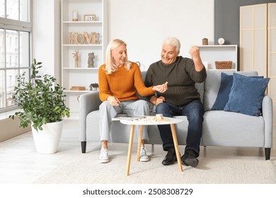 Mature couple playing jenga at home - Powered by Shutterstock