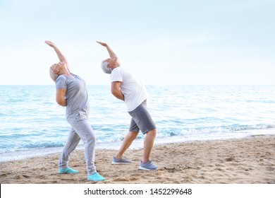 Mature couple practicing yoga at sea resort - Powered by Shutterstock