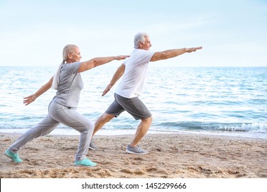 Mature couple practicing yoga at sea resort - Powered by Shutterstock