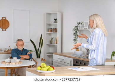 Mature couple quarreling in kitchen. Divorce concept - Powered by Shutterstock