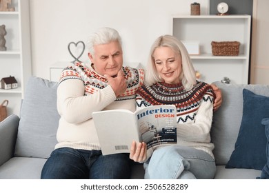 Mature couple reading magazine on sofa at home - Powered by Shutterstock