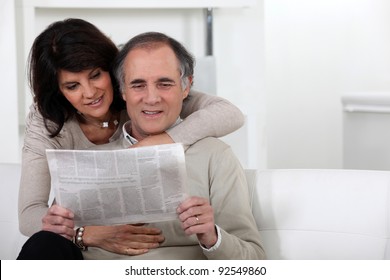 Mature Couple Reading A Newspaper