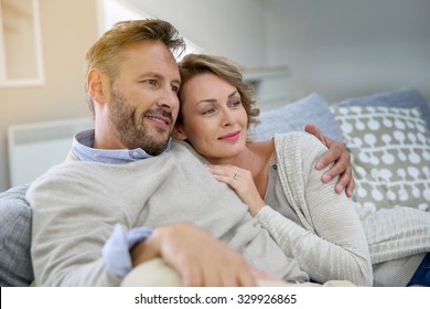 Mature Couple Relaxing In Couch At Home