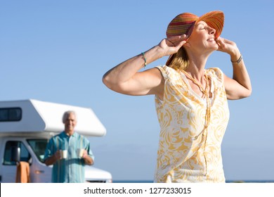 Mature couple relaxing on motor home vacation at beach - Powered by Shutterstock