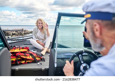 A Mature Couple Sailing On A Boat And Looking Happy