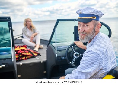 A Mature Couple Sailing On A Boat And Looking Happy