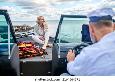 A Mature Couple Sailing On A Boat And Looking Happy