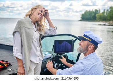 A Mature Couple Sailing On A Boat And Looking Happy