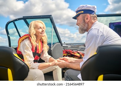 A Mature Couple Sailing On A Boat And Looking Happy