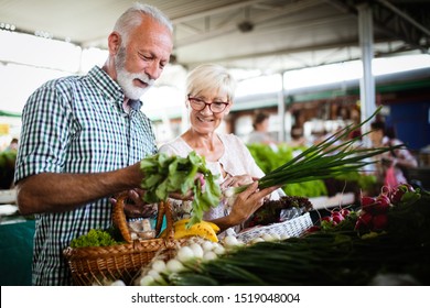 Mature couple shopping vegetables and fruits on the market. Healthy diet. - Powered by Shutterstock