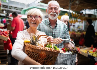 Mature couple shopping vegetables and fruits on the market. Healthy diet. - Powered by Shutterstock