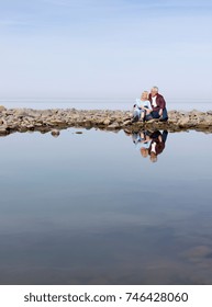 Mature Couple Sitting On Beach