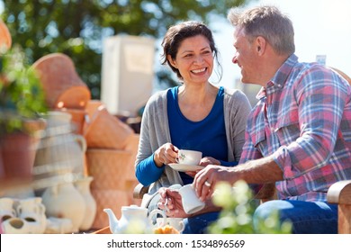 Mature Couple Sitting On Bench In Cafe Whilst Visiting Garden Center - Powered by Shutterstock