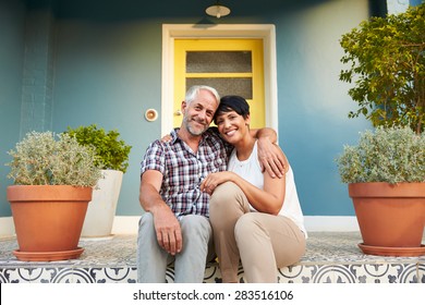 Mature Couple Sitting On Steps Outside House
