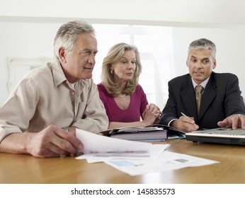 Mature couple sitting at table with financial advisor