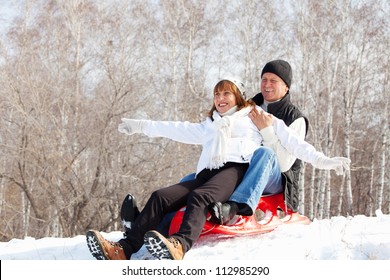 Mature Couple Sledding. Seniors Couple On Sled In Winter Park