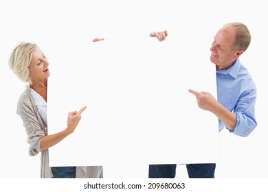 Mature Couple Smiling And Holding Card On White Background