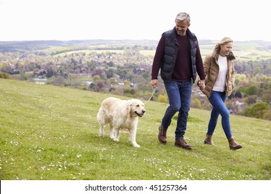 Mature Couple Taking Golden Retriever For Walk - Shutterstock ID 451257364