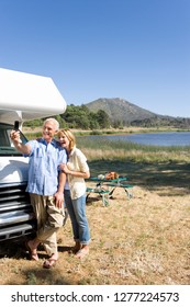 Mature Couple Taking Selfie In Countryside On Motor Home Vacation