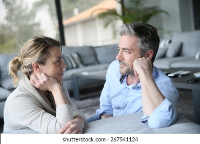 Mature couple talking to each other in sofa